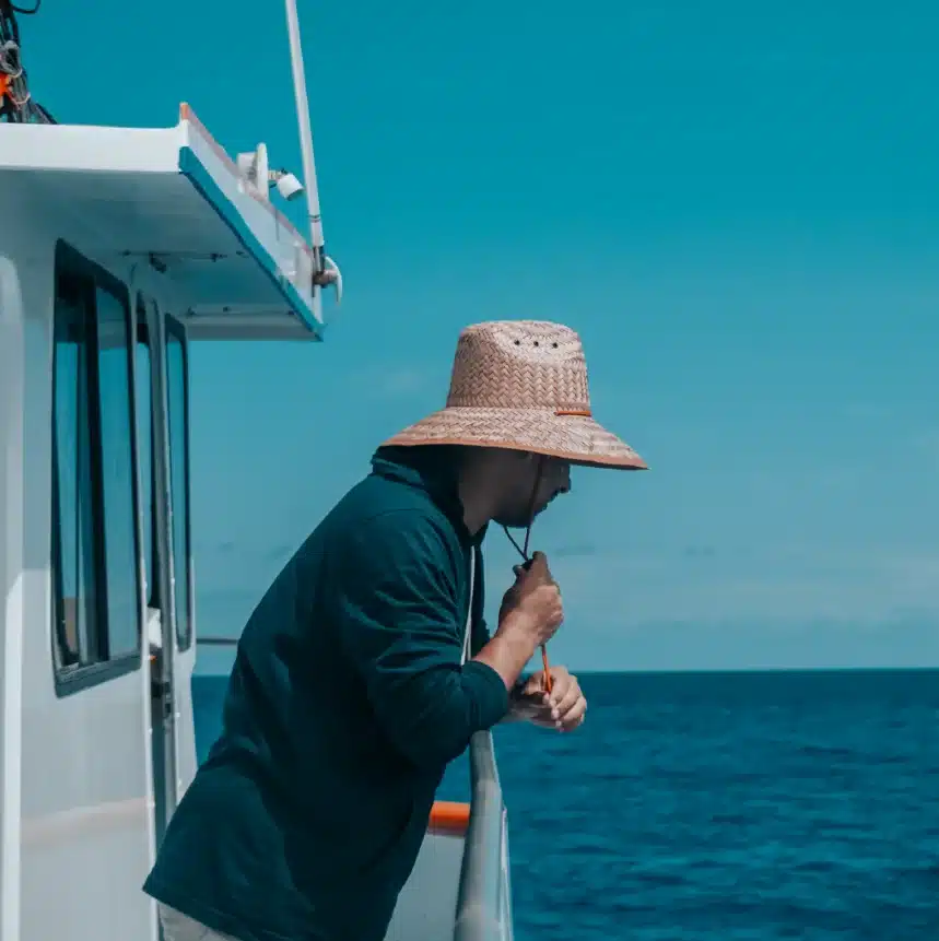 Men with a hat looking at ocean